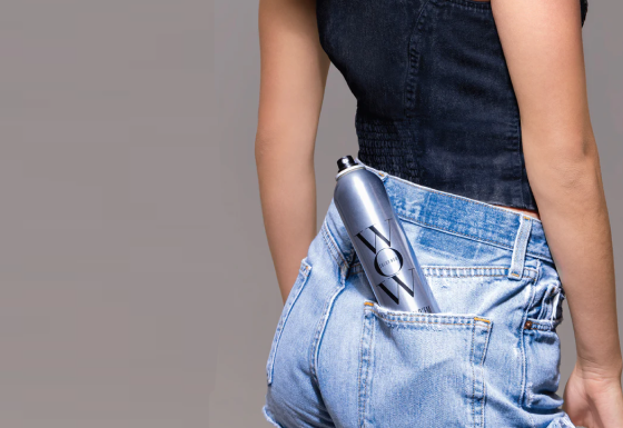 Color Wow Texas Hold ‘Em Big Hold Hairspray in back jeans pocket of woman